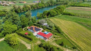 Een landelijk gelegen pand met een huis, zonnepanelen en een zwembad.