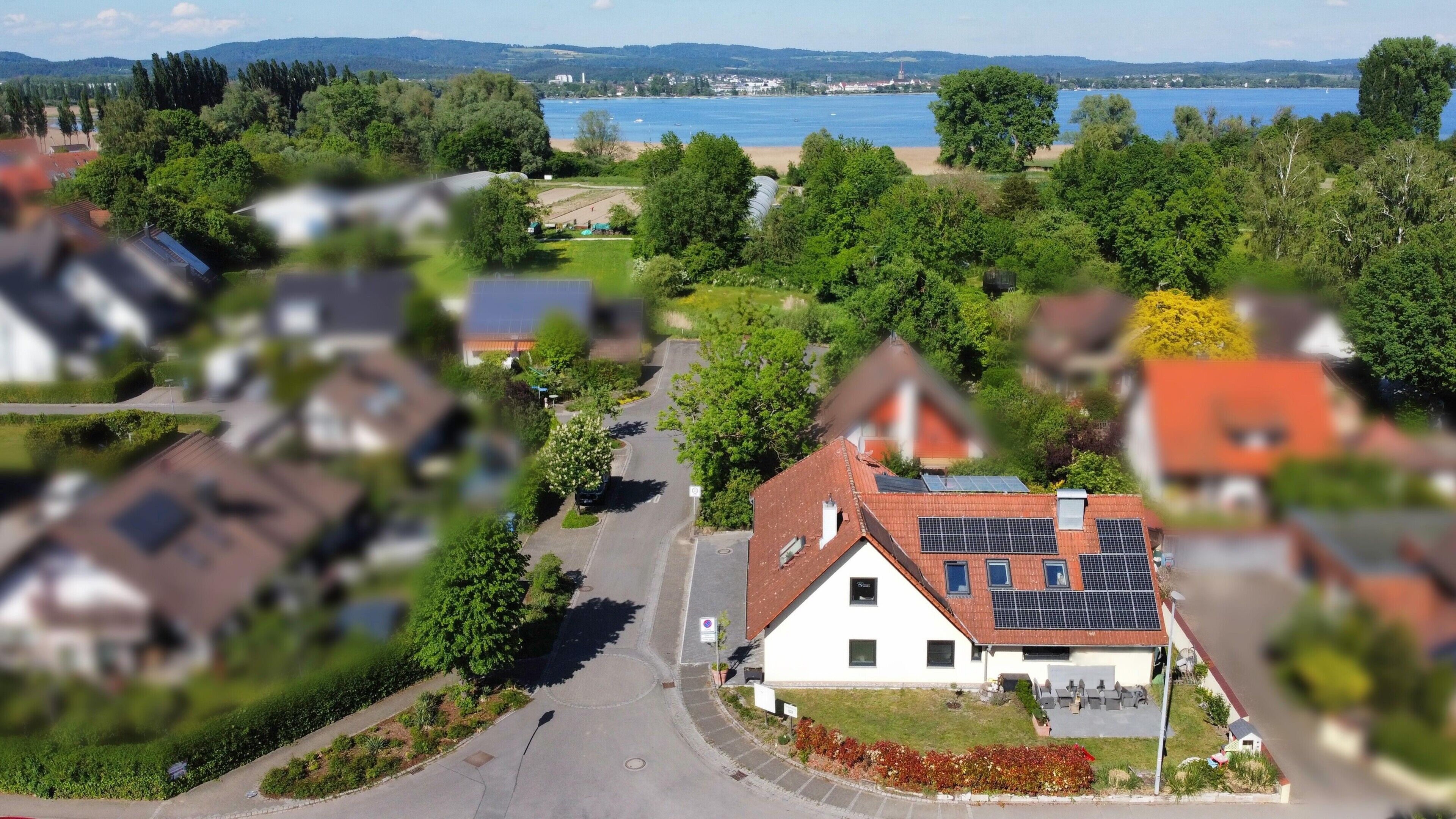 Un quartier résidentiel avec des maisons, une route et une étendue d’eau en arrière-plan.