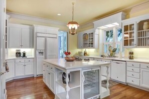 A spacious kitchen with white cabinetry, a central island, and a chandelier. - The Beautiful Armstrong Estate Downtown Sonoma (Sonoma)