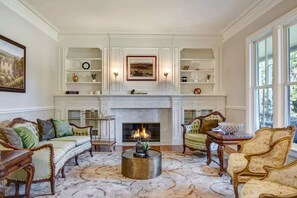 Ein traditionelles Wohnzimmer mit Kamin, kunstvollen Möbeln und dekorativen Regalen.
