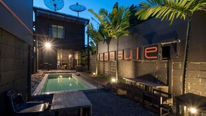 A modern building with a pool, outdoor seating, and satellite dishes. - The Urban Room (Phuket)