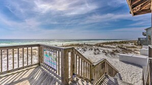 Een houten terras met uitzicht op het strand en de oceaan.