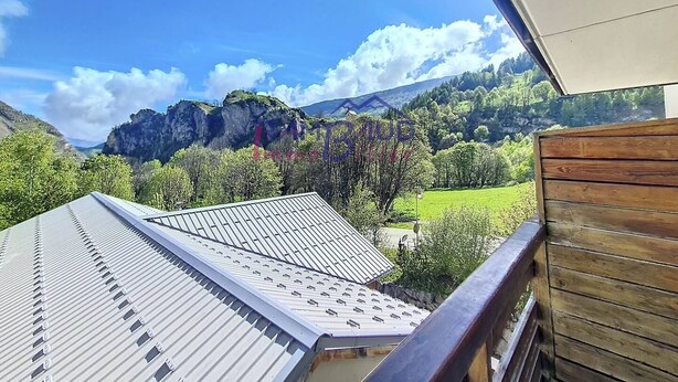 A balcony with a view of a mountainous landscape, a metal roof, and wooden railing. - 2 Rooms 4 people Swimming Pool (VALLOIRE)