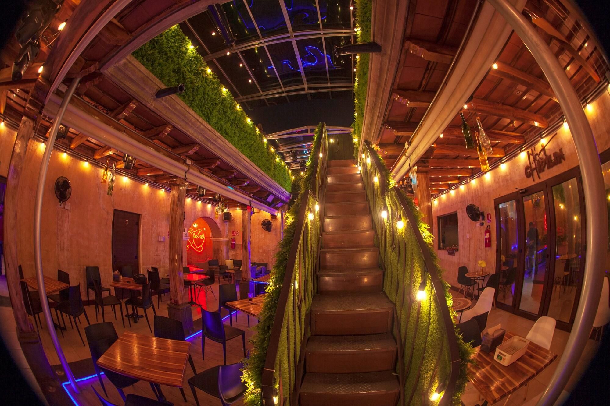 A restaurant with a spiral staircase, wooden tables, and chairs.