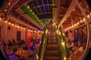 A restaurant with a spiral staircase, wooden tables, and chairs. - Hot Chipilin  (Antigua Guatemala)
