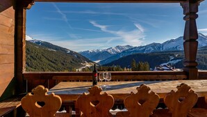 Ein Holztisch und Stühle mit Blick auf die Berge.