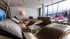 Ein modernes Hotelzimmer mit einem großen Bett, einem kleinen Tisch und Blick auf einen roten Bus vor dem Haus.