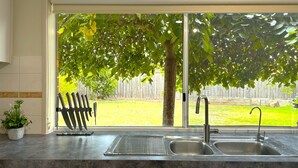 A kitchen with a large window, a sink, and a knife block. - Close to Airport (Hillside)