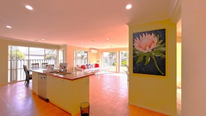 A spacious kitchen with a dining area, large windows, and a painting of a flower on the wall. - Open Range Zoo/Supper Comfortable Beds/Shopping Center (Point Cook)