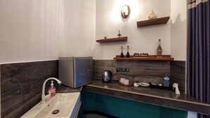 A modern bathroom with a sink, a mirror, a small refrigerator, and a shelf with decorative items. - Chen villa - Near Airport (Seeduwa - Katunayake)