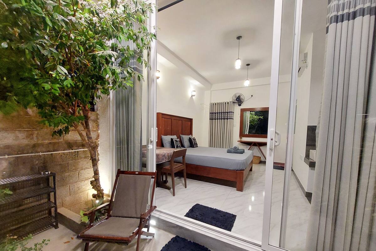 Une chambre moderne avec un lit, un bureau, une chaise et un grand miroir.