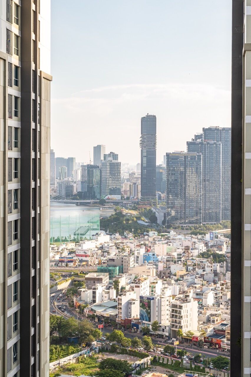 A cityscape with high-rise buildings, a river, and a bridge in the background.