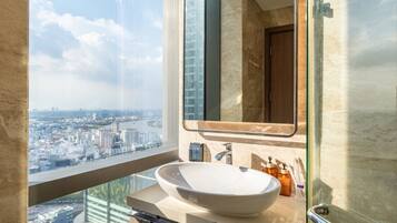 A modern bathroom with a large window, a white sink, and a mirror.