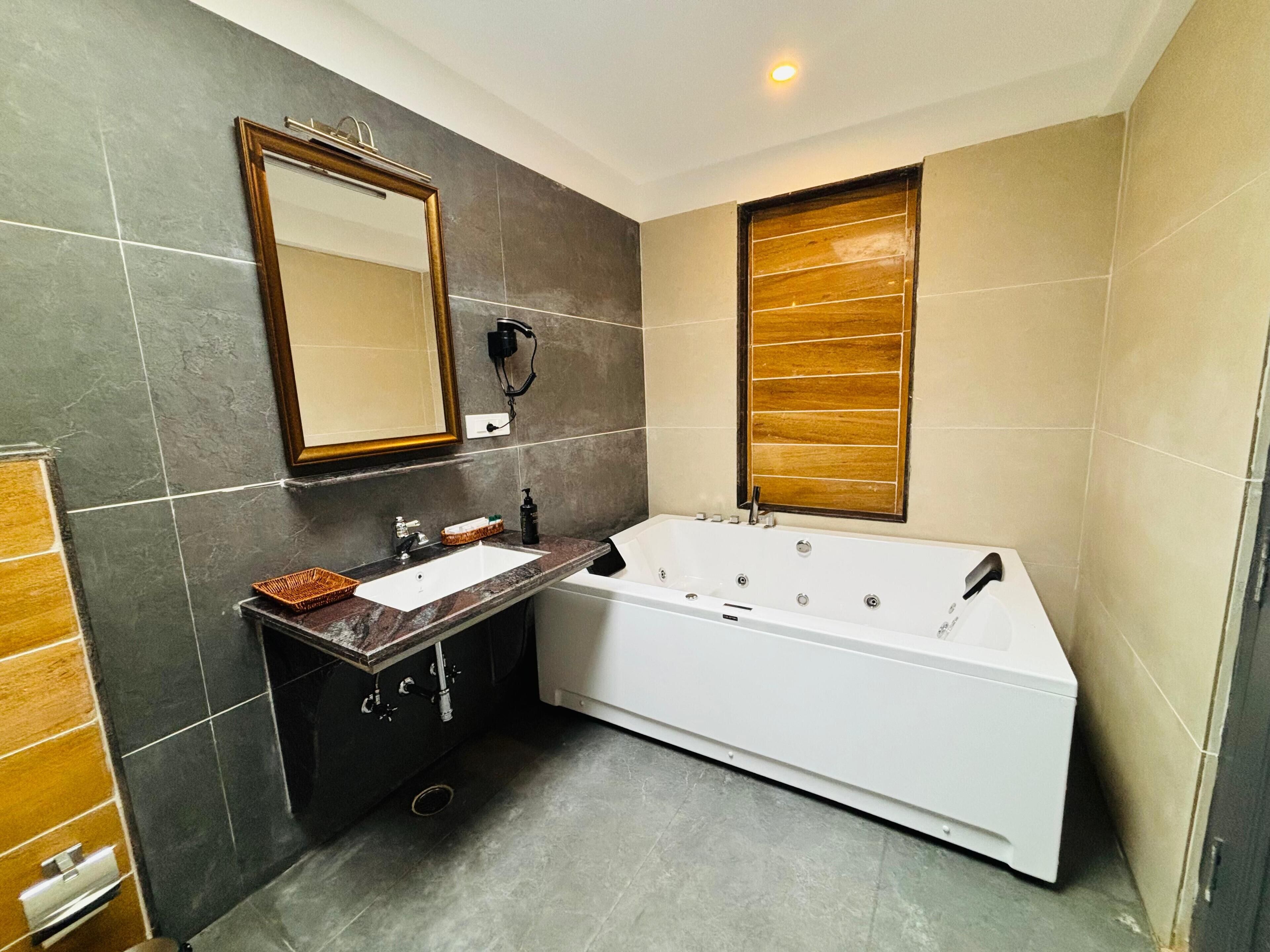 A modern bathroom with a large bathtub, a vanity with a sink, and a mirror.