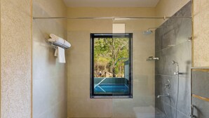 Un baño moderno con cabina de ducha de vidrio, un perchero y vistas al exterior.