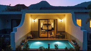Un hotel moderno con piscina, comedor y un dormitorio visible a través de un ventanal.