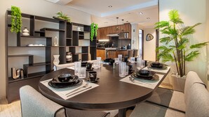 Een moderne eetruimte met een ronde tafel voor vier personen, omringd door donkere wandplanken met decoratieve planten.