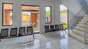 Un vaste espace intérieur doté d’un sol carrelé, d’un escalier et d’une rangée de chaises d’attente.
