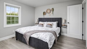 A bedroom with a large bed, a window, and a door. - Spectacular Single Level Estate, Pet Friendly, Huge Fully Fenced Backyard, Covered Patio, Game Room (Portland)