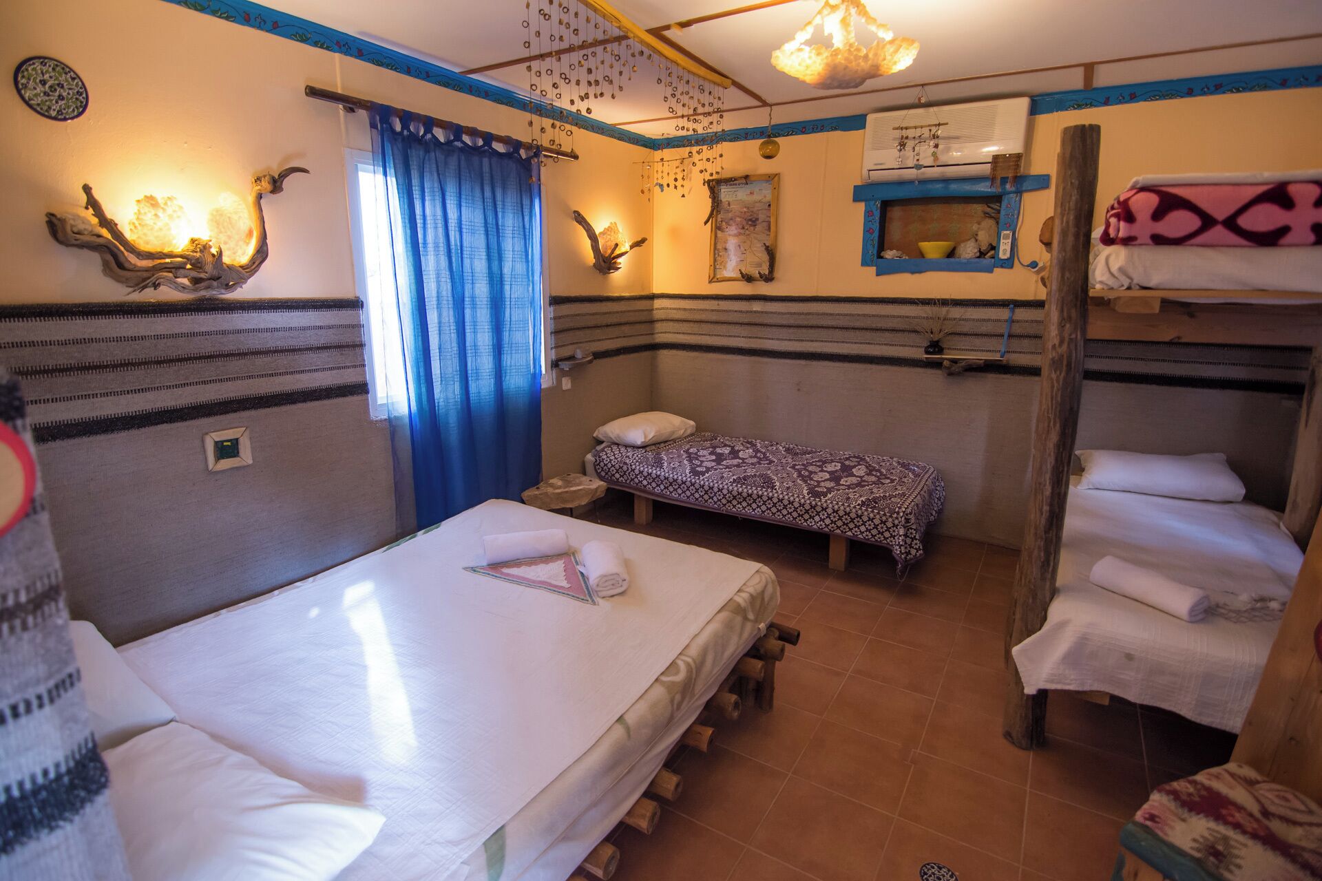 Ein Schlafsaalzimmer mit Etagenbetten, einem kleinen Tisch und einem an der Wand montierten Heizgerät.