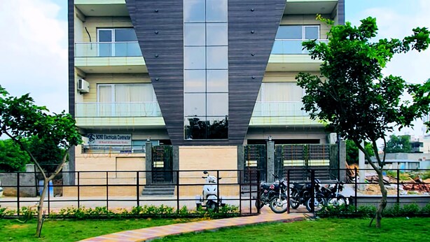 Un edificio de varios pisos con señalización para M.K. Palace Hotels y un restaurante.