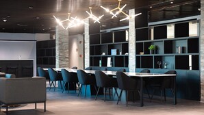 A modern conference room with a long table, black chairs, and a unique geometric ceiling light fixture. - HOTEL TANO (Tamuning)