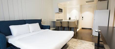 Ein Hotelzimmer mit einem Bett, einem Schreibtisch, einem Stuhl, einer Mikrowelle und einem Kühlschrank.