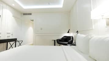Una habitación de hotel con una cama, un escritorio, una silla y una mesita.