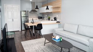 A modern kitchen with a refrigerator, microwave, and dining area. - HOTEL TANO (Tamuning)