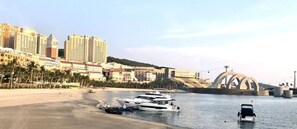 A marina with several boats docked, a bridge, and high-rise buildings in the background. - TEDDY 108 HOMESTAY & CAFE - GRAND WORLD PHU QUOC (Phu Quoc)