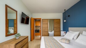 A hotel room with a bed, a dresser, a TV, a wardrobe, and a kitchenette. - Elli Down Town Apartment Karma (Rodos)