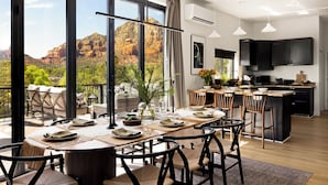 Une cuisine moderne dotée d’un grand îlot central, d’un coin repas offrant une vue agréable et d’un balcon aménagé avec des sièges d’extérieur.