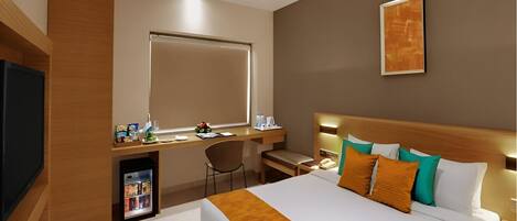 A modern hotel room with a large bed, a desk, a chair, a television, and a ceiling fan.