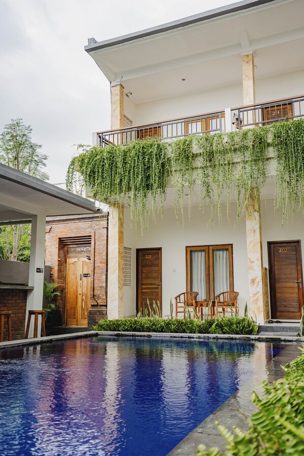 A two-story building with a swimming pool in front.