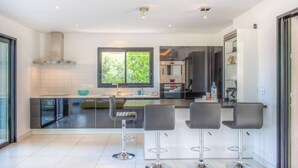 Une cuisine moderne dotée d’un îlot central, de tabourets de bar et d’une grande fenêtre.