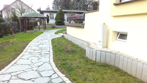 Un camino de piedra que lleva a un mirador de madera en una zona residencial.