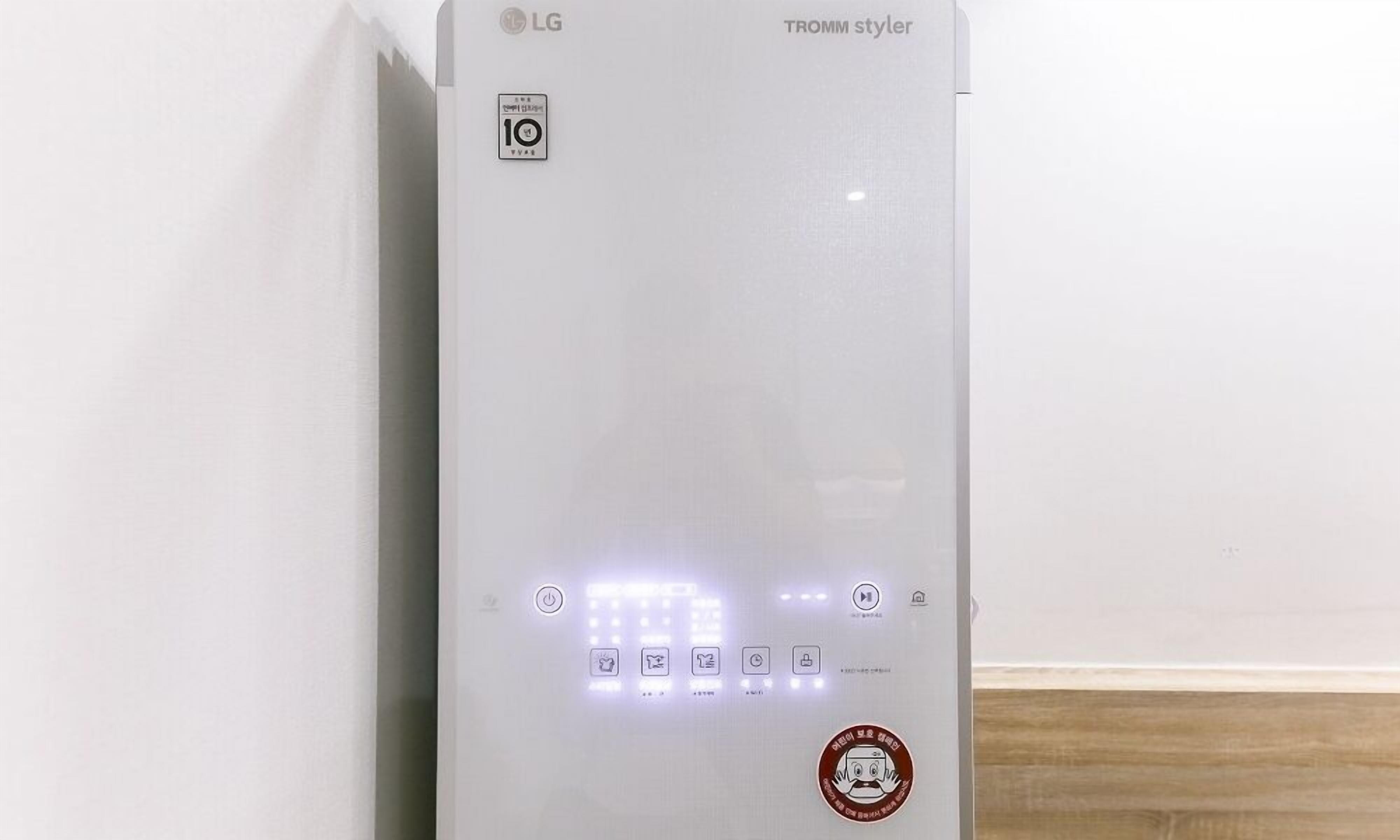 A white LG TROMM styler with a 10-year warranty, a power button, and several control icons.