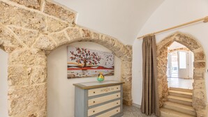 A stone-walled room with a wooden dresser and a painting of a tree. - Appartamento Misya - Felline (Felline)