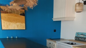 A kitchen with white cabinetry, a black countertop, and a blue wall.