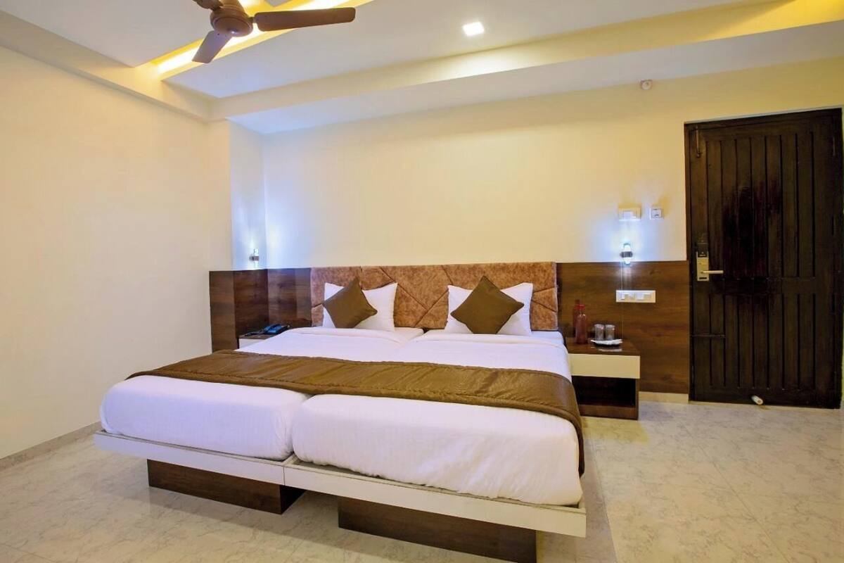 A double bed with a wooden headboard, a bedside table with a lamp, and a ceiling fan.