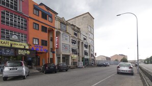 Un hotel con un letrero que dice "HOTEL AMAN" y un número de teléfono visible.