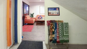 Un vestíbulo de hotel con un tapete de oración, un sofá, una mesa de centro y una zona alfombrada.