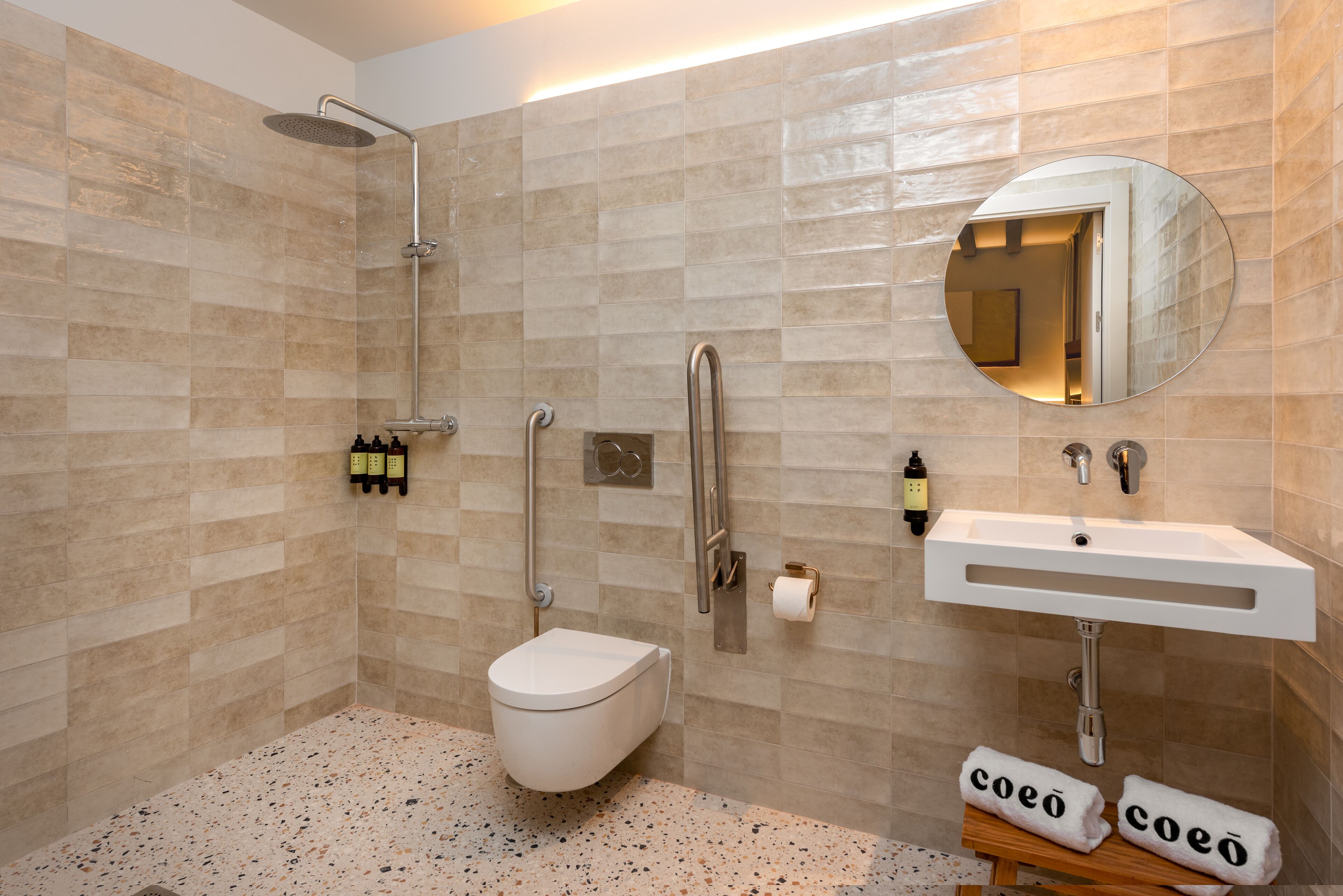 Un baño moderno con ducha, inodoro, lavamanos y espejo.