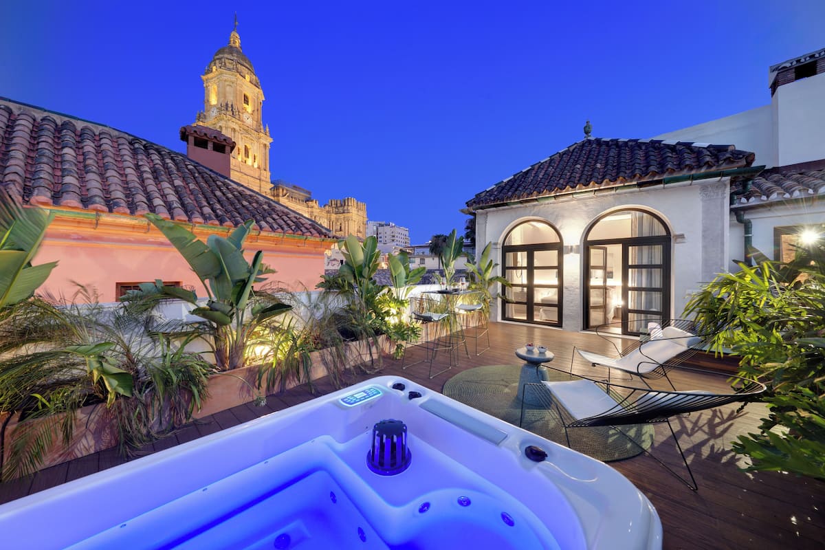 A hot tub in a courtyard with a view of a historic building and a modern house.