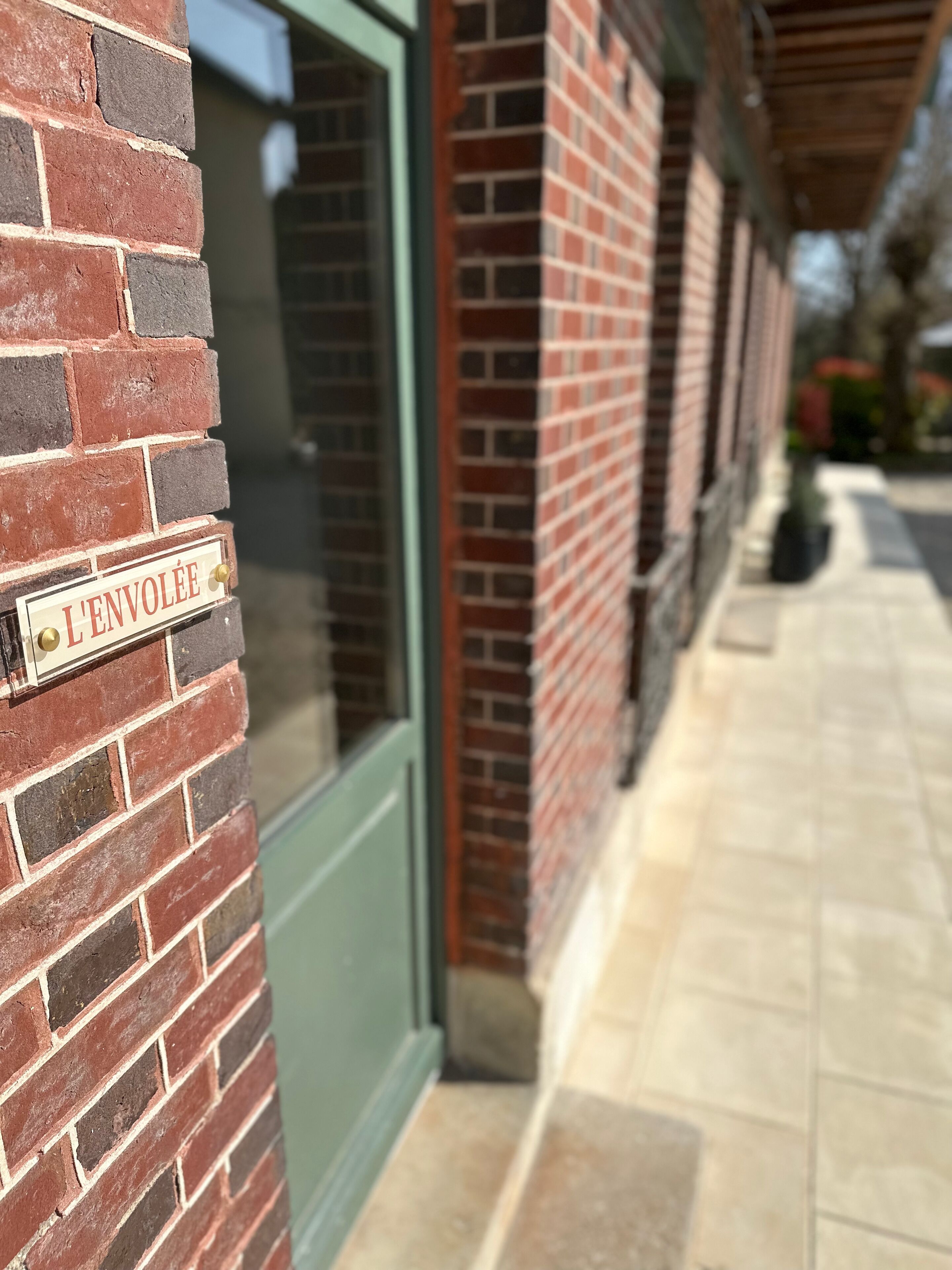 A brick building with a sign reading "L'ENVOLEE".