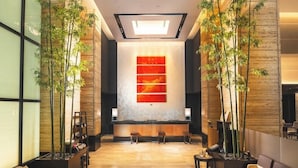A reception area with a modern design, featuring a reception desk, seating area, and decorative plants. - Koko Hotel Premier Kanazawa Korinbo (Kanazawa)