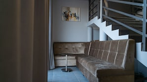 A modern living room with a brown sofa, a small round table, and a staircase. - THE TIME HOTEL (Tashkent)