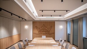 A conference room with a long table, chairs, and a decorative wall panel. - Hotel Dreiflüssehof Gästehaus (Passau)