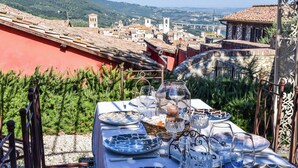 A table set outdoors with a view of a town and hills in the background. - Villa in the historical center with private garden, pool, spa and AC (Narni)