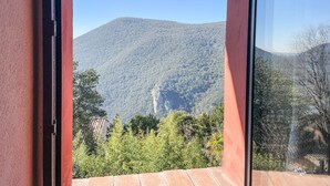 A mountain view from a room with a red wall and a window. - Villa in the historical center with private garden, pool, spa and AC (Narni)